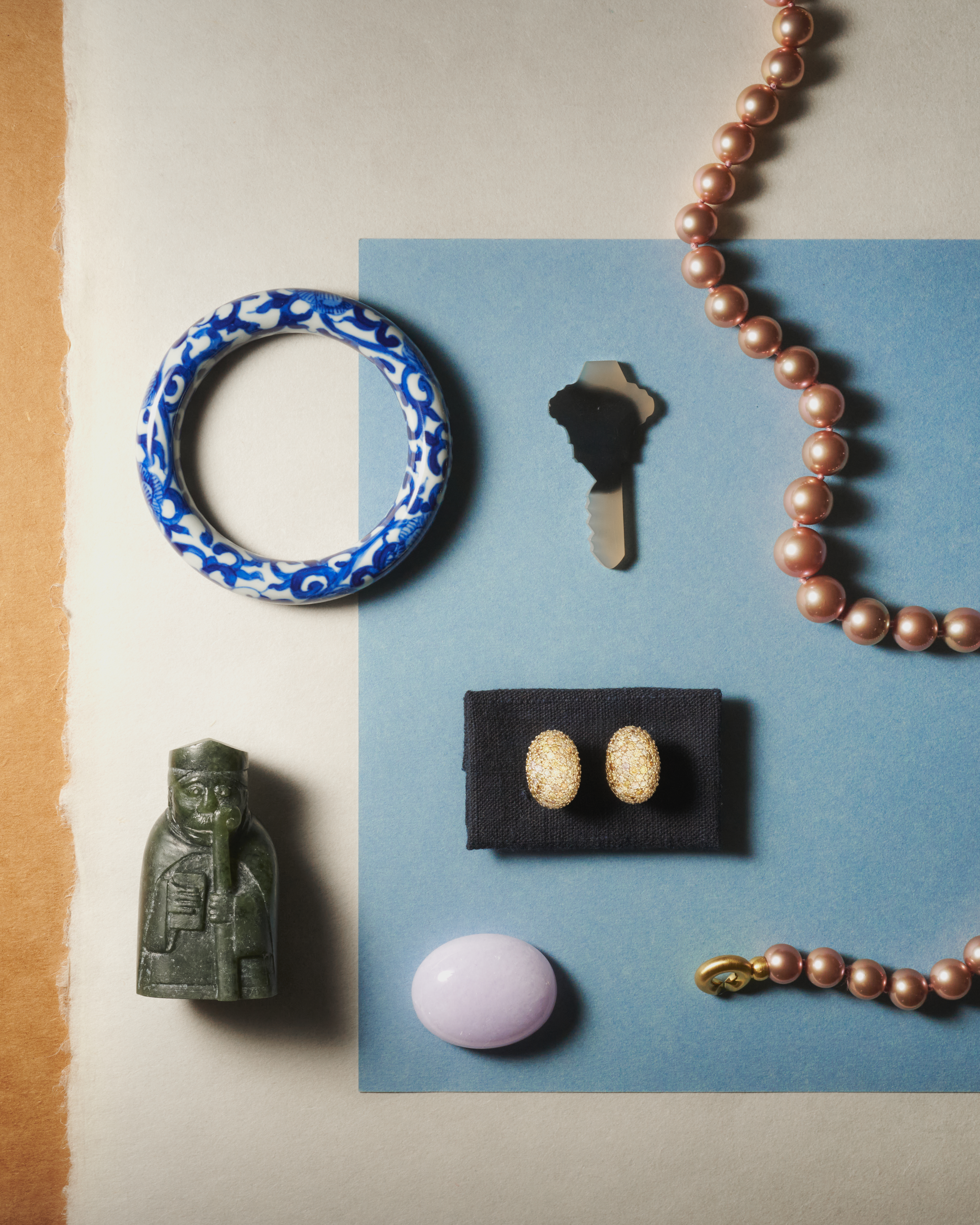 Carved jade bangle, snuff bottle and pearl necklace arranged on paper