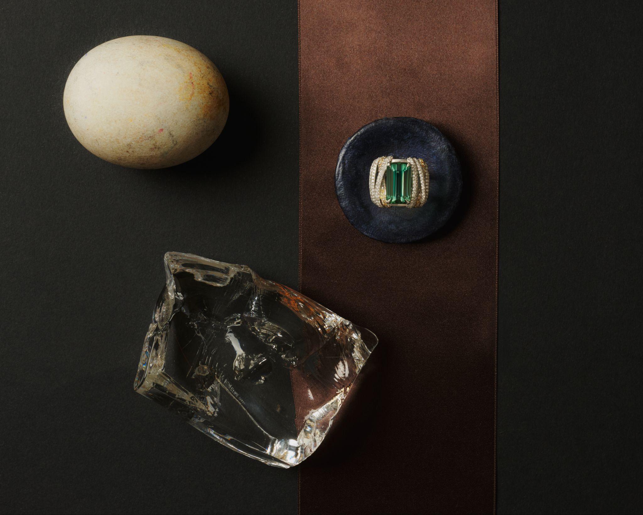 Still life with egg, glass form, and tourmaline ring