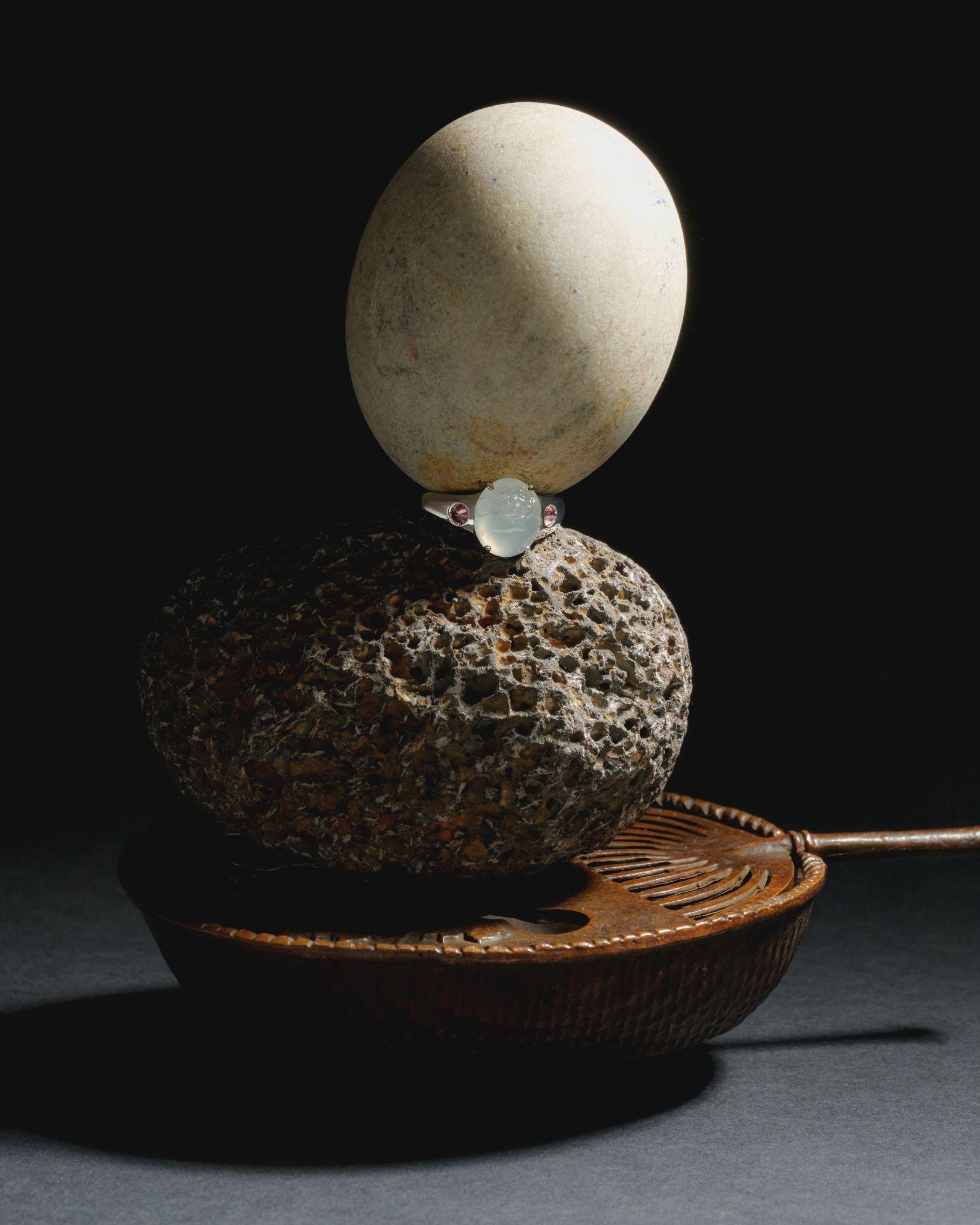 Ostrich egg balanced on a stone, jewelry vignette