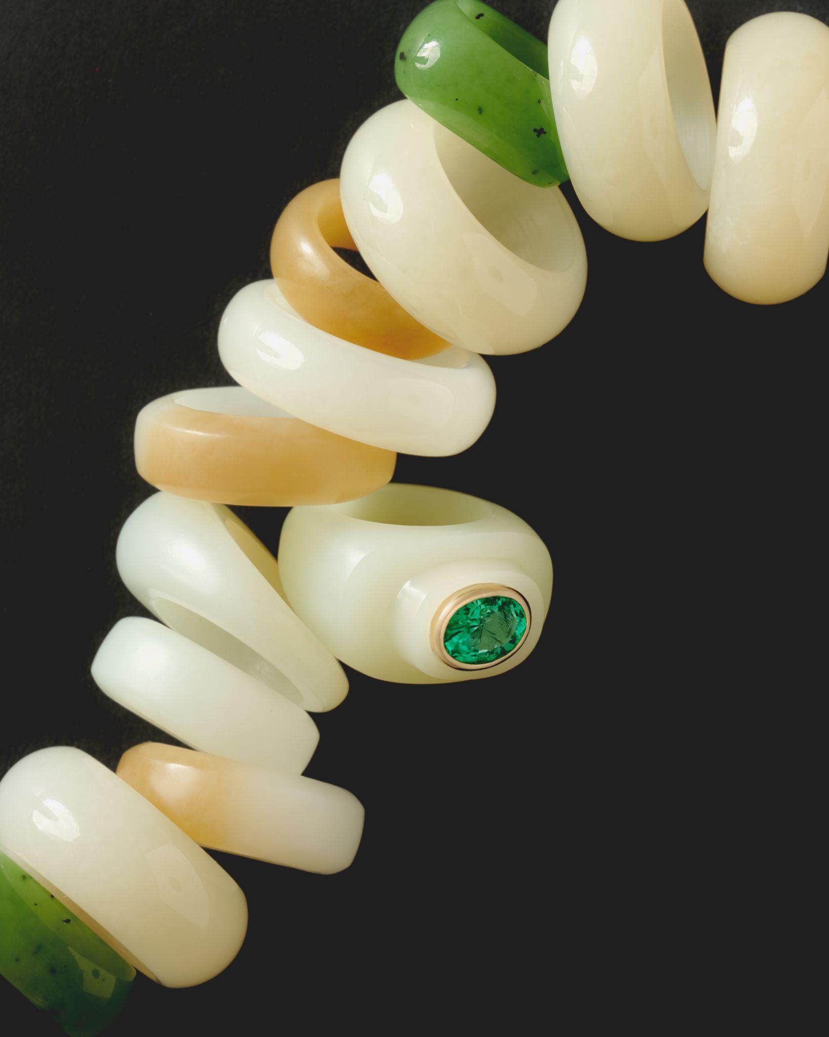 Stacked bakelite and jade rings on dark ground