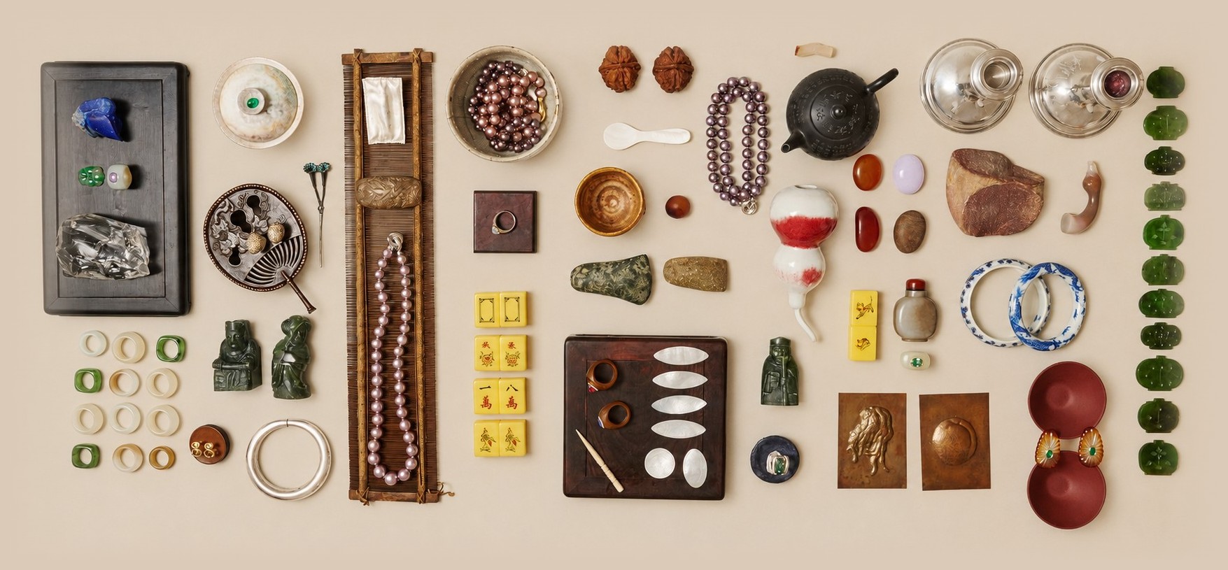 A collector's table of jade, silver, pearl and carved stone objects