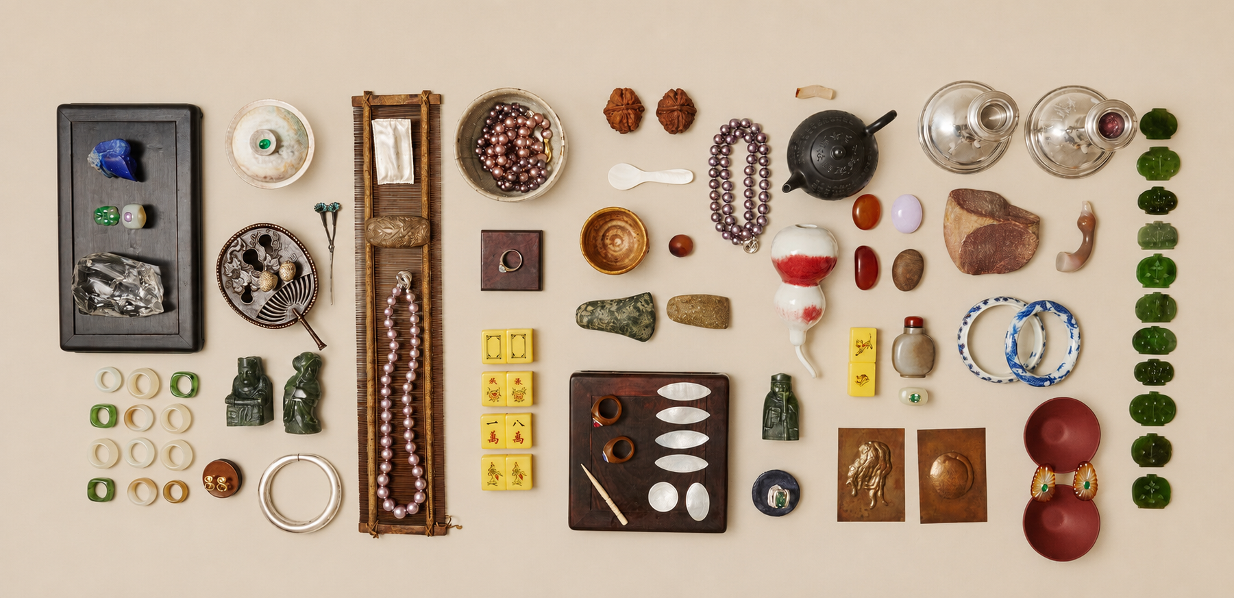 A collector's table of jade, silver, pearl and carved stone objects